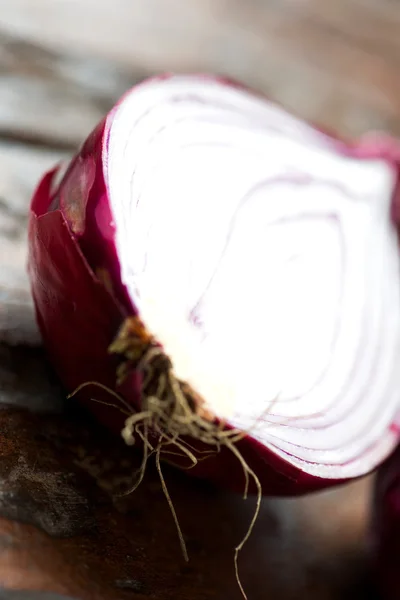 Cebolla roja fresca en una vieja mesa de madera de cerca — Foto de Stock