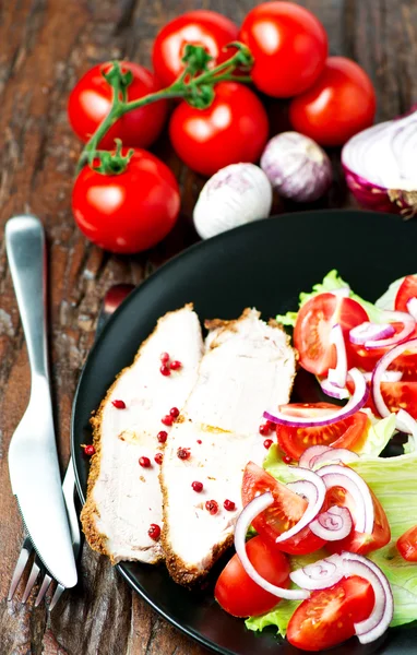 Жареная свинина в тарелке с салатом — стоковое фото