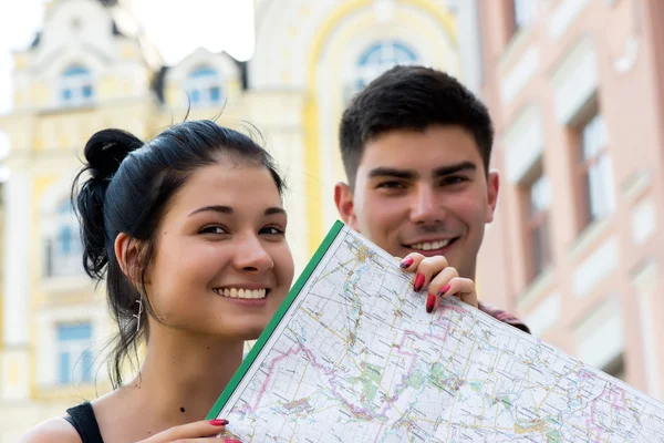 Ungt par i stan med turistiska karta — Stockfoto