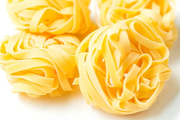 Dry pasta tagliatelle on tablecloth — Stock Photo, Image