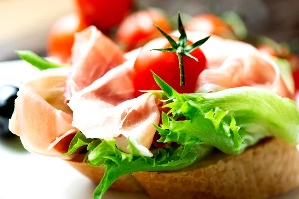 Sandwiches with prosciutto on plate macro — Stock Photo, Image