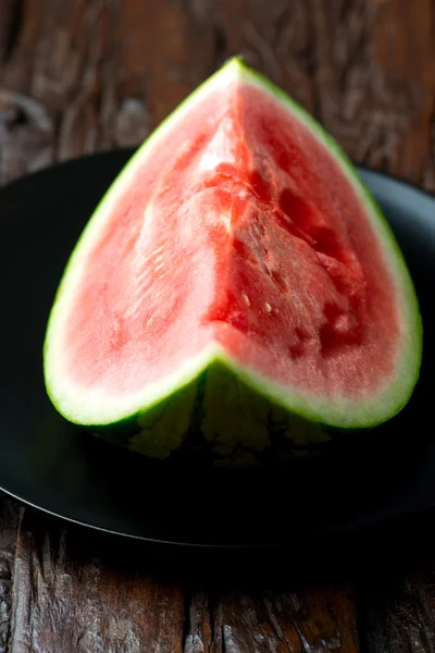 Röd vattenmelon i plattan på träbord — Stockfoto