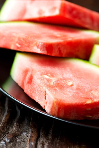 Röd vattenmelon i plattan på träbord — Stockfoto