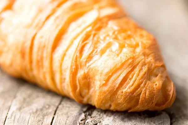 Croissant on wooden table — Stock Photo, Image