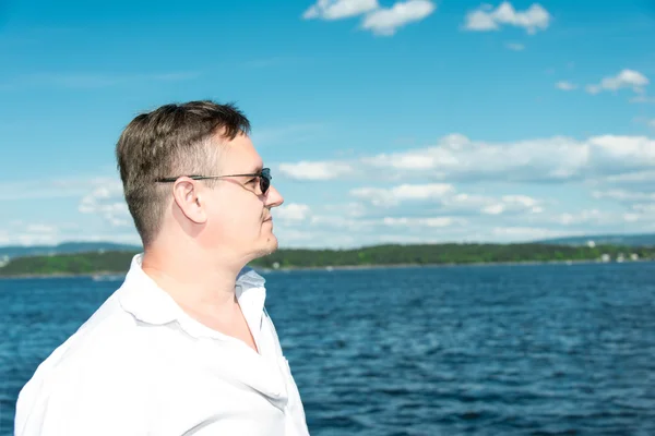 Ritratto dell'uomo in occhiali da sole con mare sullo sfondo — Foto Stock