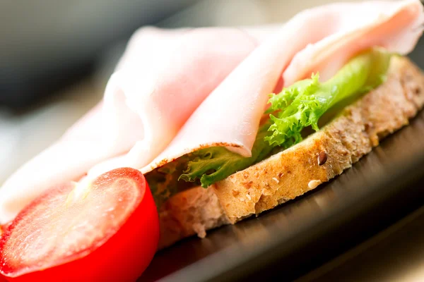 Sandwich skinka tomat sallad blad på nära håll — Stockfoto