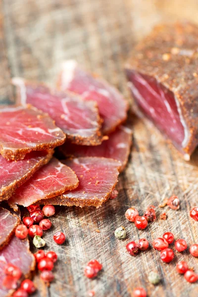 Scheiben gepökeltes Fleisch und Pfeffer — Stockfoto