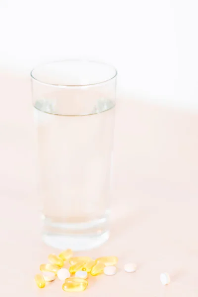 Pillen en glas water verticaal — Stockfoto