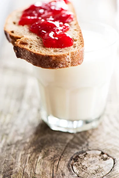 Pan con mermelada de fresa y vaso de leche — Foto de Stock