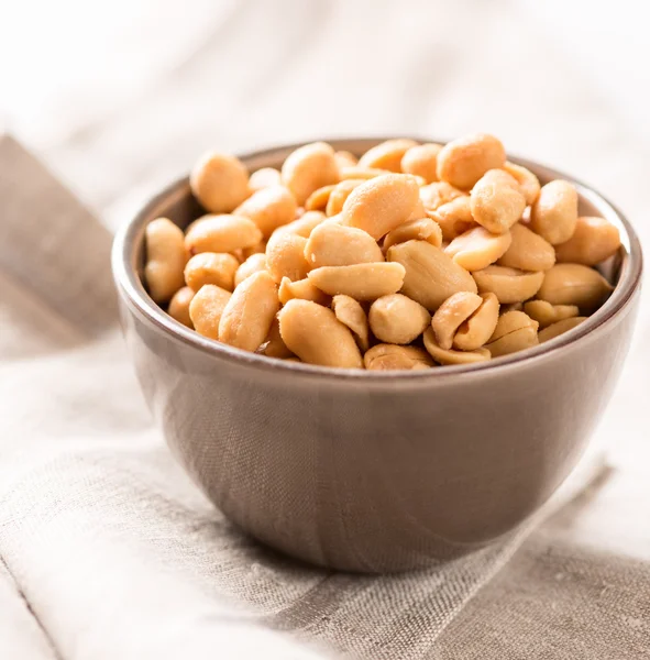 Peanuts in a bowl on tablecloth square — Stock Photo, Image