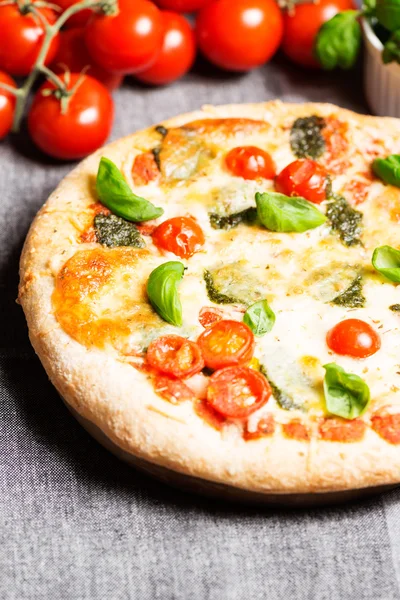 Italian pizza on tablecloth with tomatoes top view — Stock Photo, Image