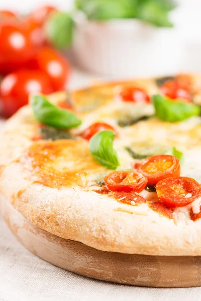 Italian pizza on tablecloth with tomatoes closeup — Stock Photo, Image