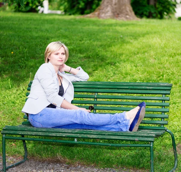 Handsome blond woman on bench — Stock Photo, Image