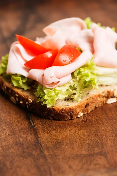 Skinksmörgås med tomat nära upp vertikala — Stockfoto