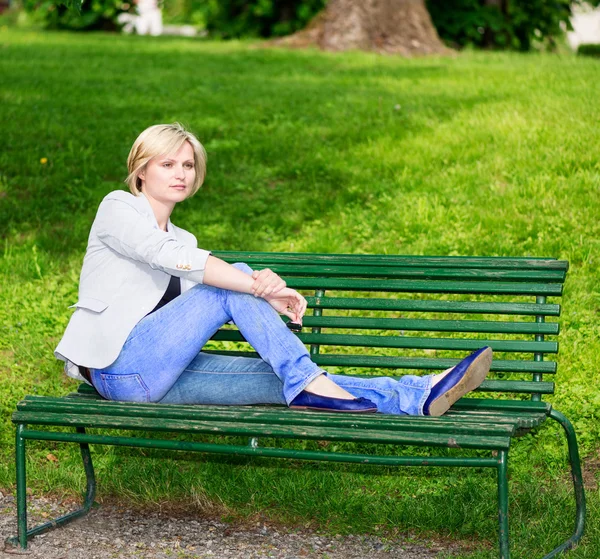 Blond kobieta na ławce — Zdjęcie stockowe