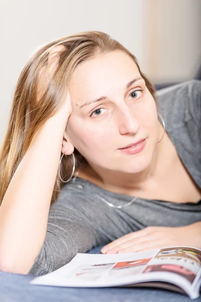 Brunette reading magazine vertical — Stock Photo, Image