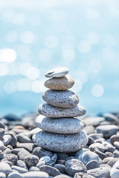 Stones pyramid with ocean on background — Stock Photo, Image