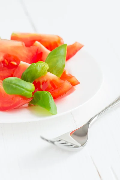 Tomaten mit Basilikumblättern — Stockfoto