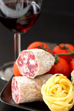 Salami with tomatoes, pasta and wine clipart