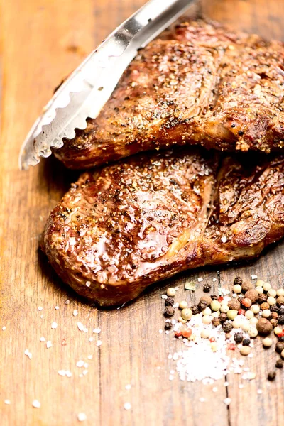 Grilled steaks on board — Stockfoto