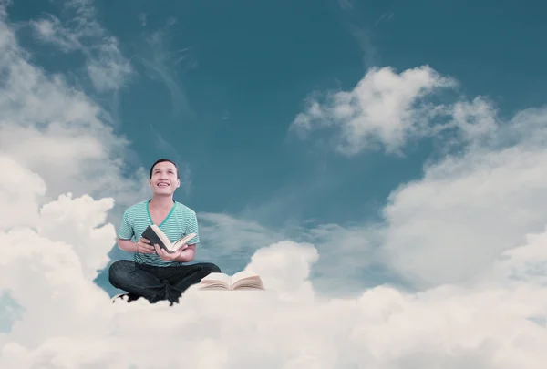 Young man reading a book in the clouds — Stock Photo, Image