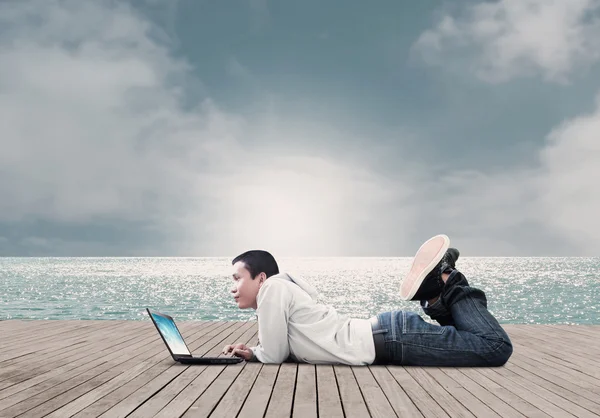 Homme avec ordinateur portable sur la plage — Photo