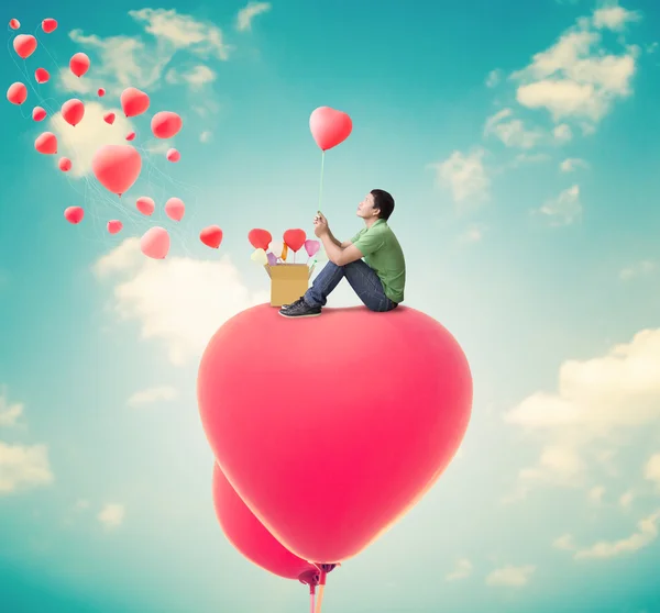 Homme avec des ballons cardiaques, fond Saint-Valentin — Photo