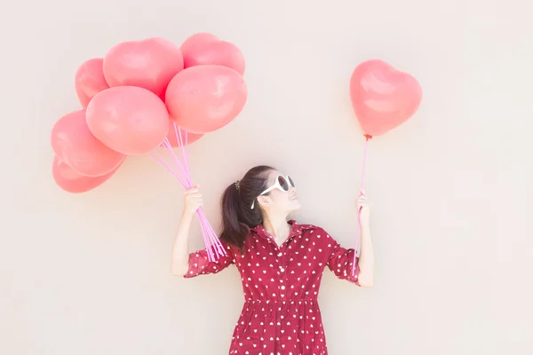 Meisje met kleurrijke hart ballonnen — Stockfoto