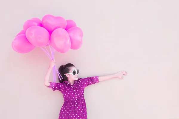 Menina com balões coloridos do coração — Fotografia de Stock