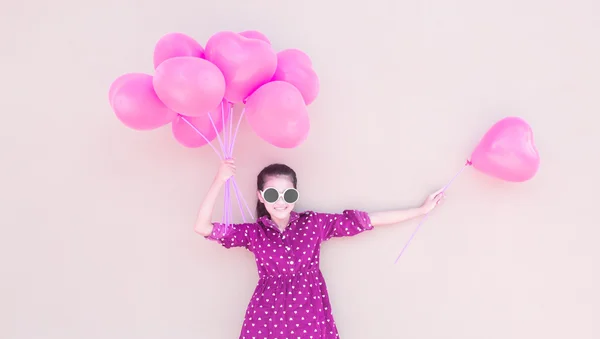 Meisje met kleurrijke hart ballonnen — Stockfoto