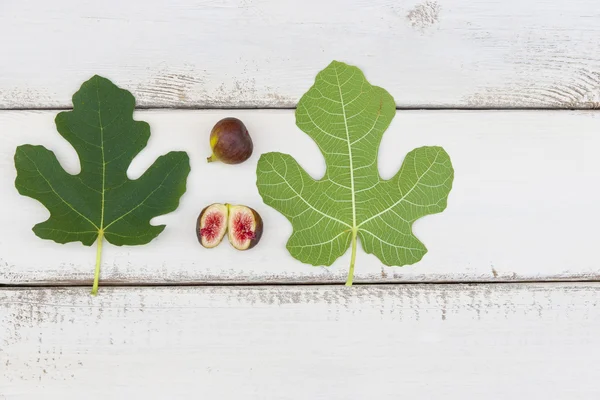 熟した新鮮なイチジクの果実と葉白素朴な木製のボードの wi — ストック写真