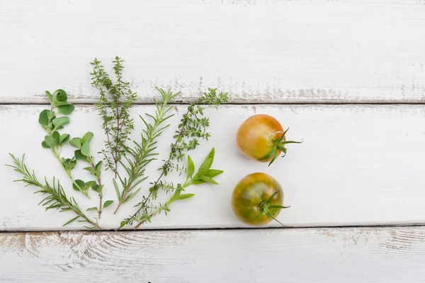 Zioła wychowanków i pomidory na rustic deska drewno — Zdjęcie stockowe