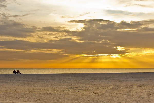 Paar zittend op het strand kijken naar zonsondergang — Stockfoto