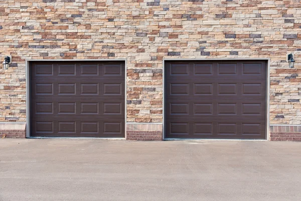 Duas portas de garagem na parede de tijolo . — Fotografia de Stock