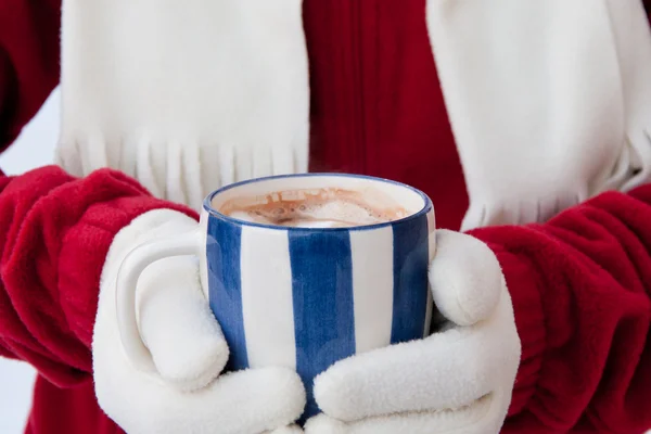 Woman in warm gloves holding cup of hot chocolate with marshmall