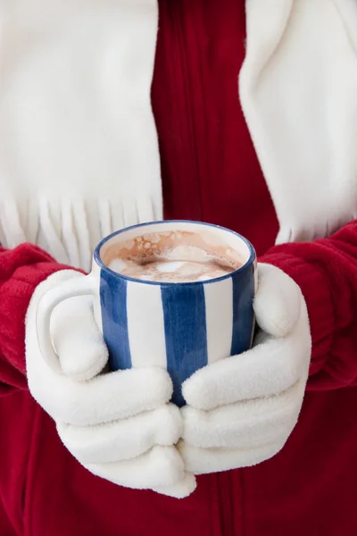 Mulher em luvas quentes segurando xícara de chocolate quente com shopping — Fotografia de Stock