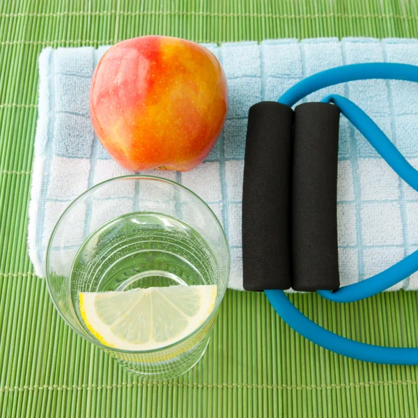 Gezonde levensstijl concept - water, apple, expander en handdoek. — Stockfoto