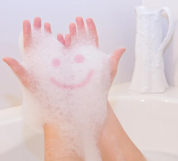 Sonrisa en espuma de jabón en las manos — Foto de Stock