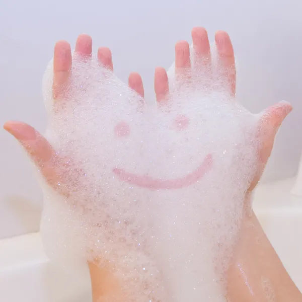 Sonrisa en espuma de jabón en las manos — Foto de Stock