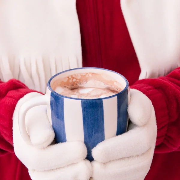 Mulher em luvas quentes segurando xícara de chocolate quente com shopping — Fotografia de Stock