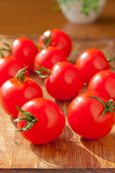 Pomidory na drewnianą deską do krojenia — Zdjęcie stockowe