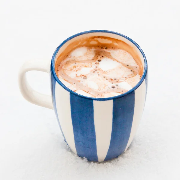 Copa de chocolate caliente con malvaviscos derretidos en la nieve — Foto de Stock