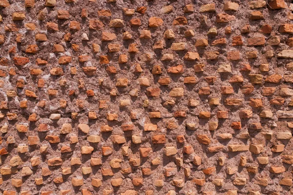 Old ancient brick wall composed of thin clay bricks placed at