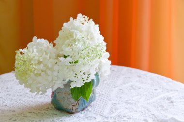 bir masaya beyaz ortanca çiçek buketi.