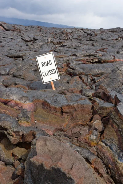 The Road Closed sign on the road buried in lava from the erupti — Stock Photo, Image