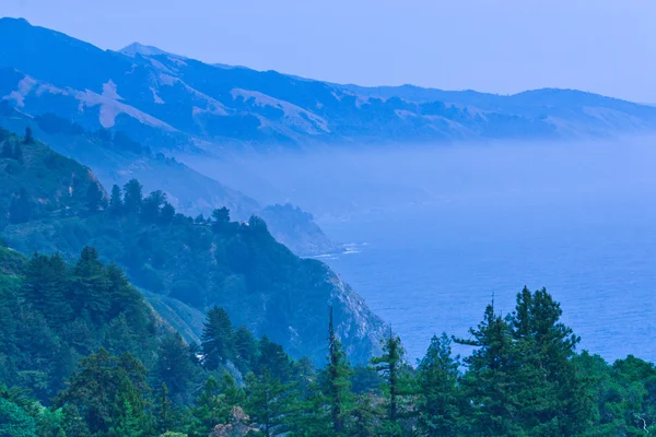 Stille Oceaan baai in een blauwe mist mist. — Stockfoto