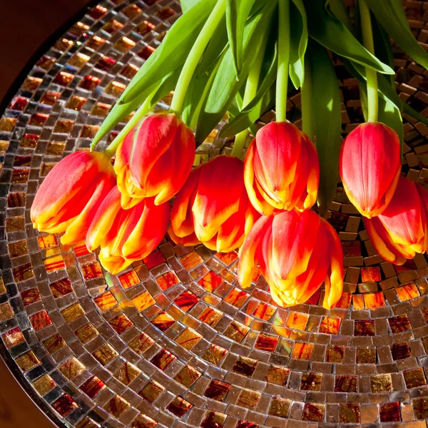 Tulipanes rojos sobre mesa de mosaico . —  Fotos de Stock
