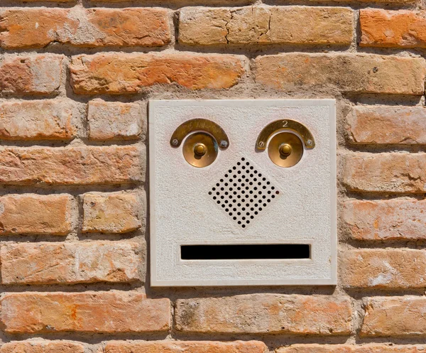 A modern intercom doorbell panel on old brick wall. Stock Picture