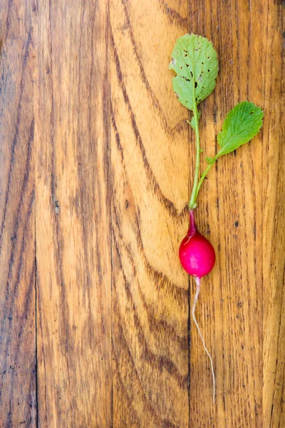 Kleiner Gartenrettich auf dunklem Holzbrett. — Stockfoto