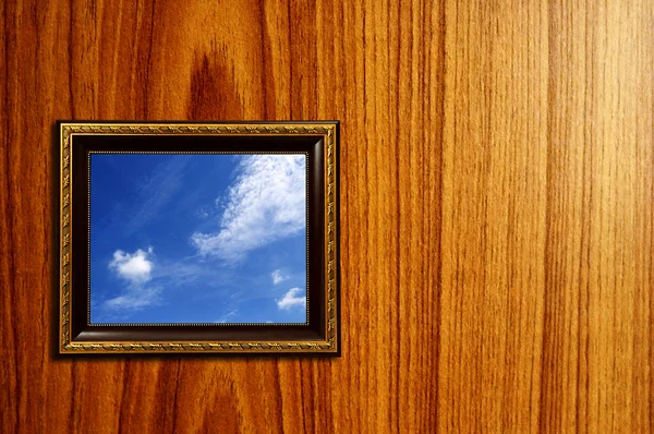 Uma foto de uma moldura de madeira com a configuração do céu dentro — Fotografia de Stock